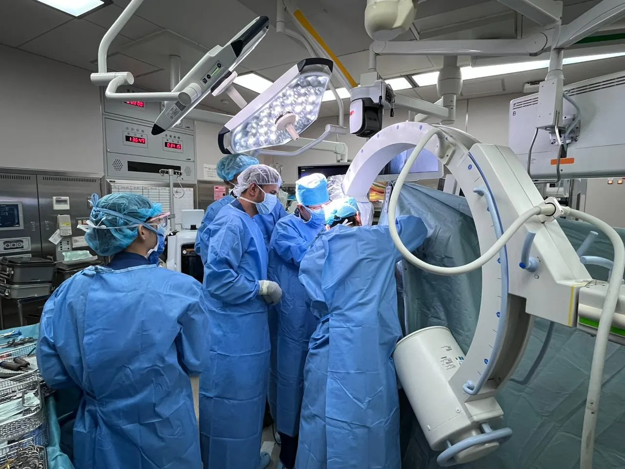 Operating theatre team working with C-arm imaging during a procedure