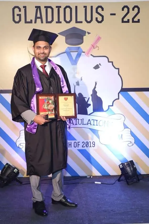Dr. Karwande at his medical college convocation ceremony, holding his medal and citation