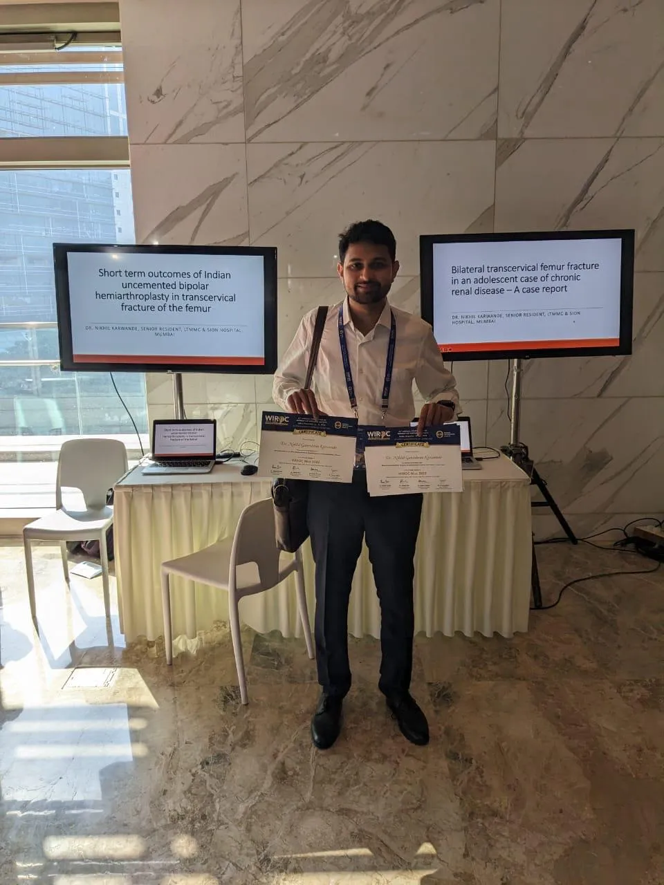 Dr. Karwande holding certificates for two research papers presented at WIROC, on Indian bipolar hemiarthroplasty outcomes and a bilateral femur fracture case report